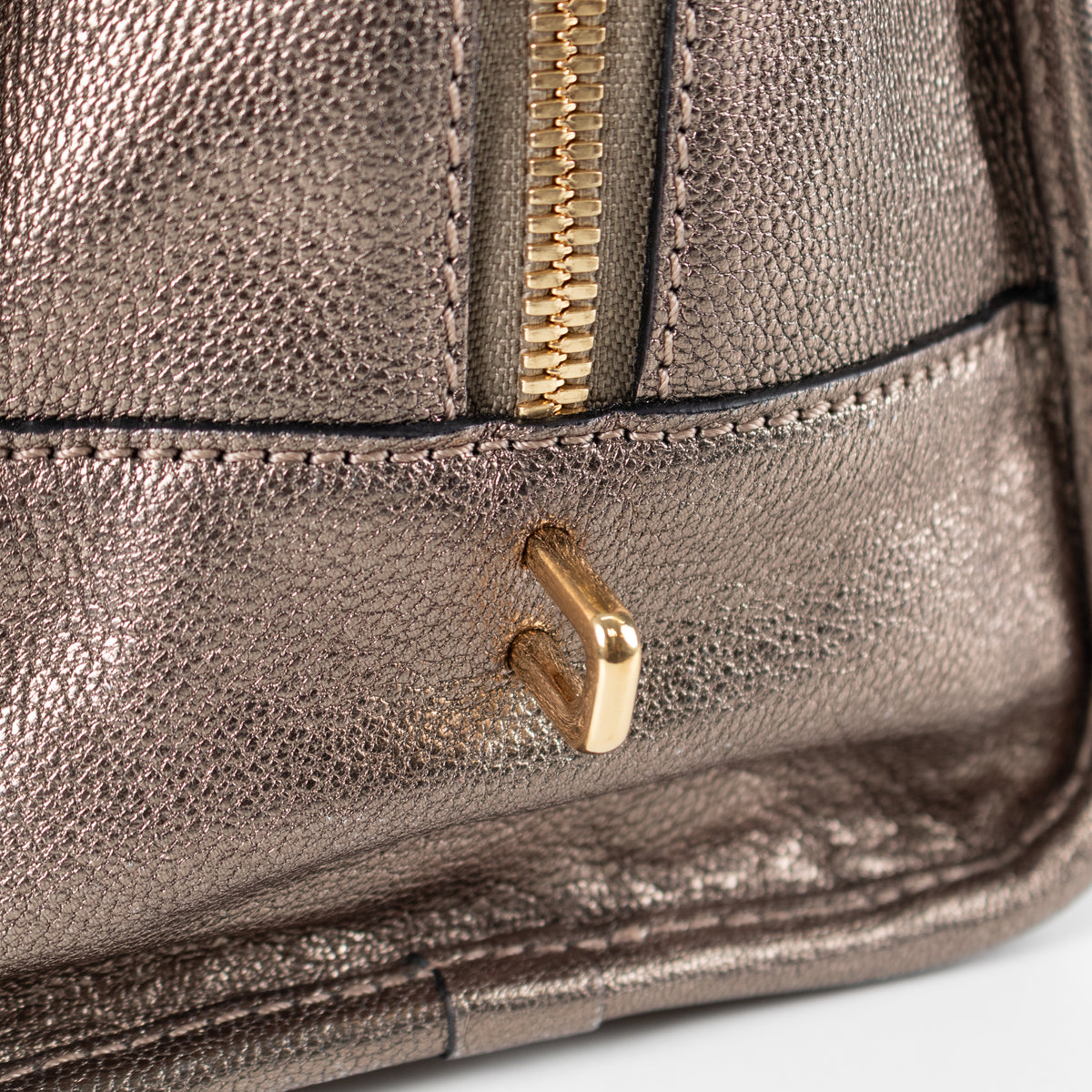 Close up of gold metal hardware and gold zip on pre loved Loewe Gold Tone Amazona Bag
