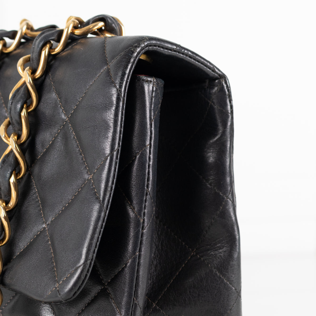 Close up of Black Chanel Vintage 34 Maxi Lambskin Single Flap bag on white background.