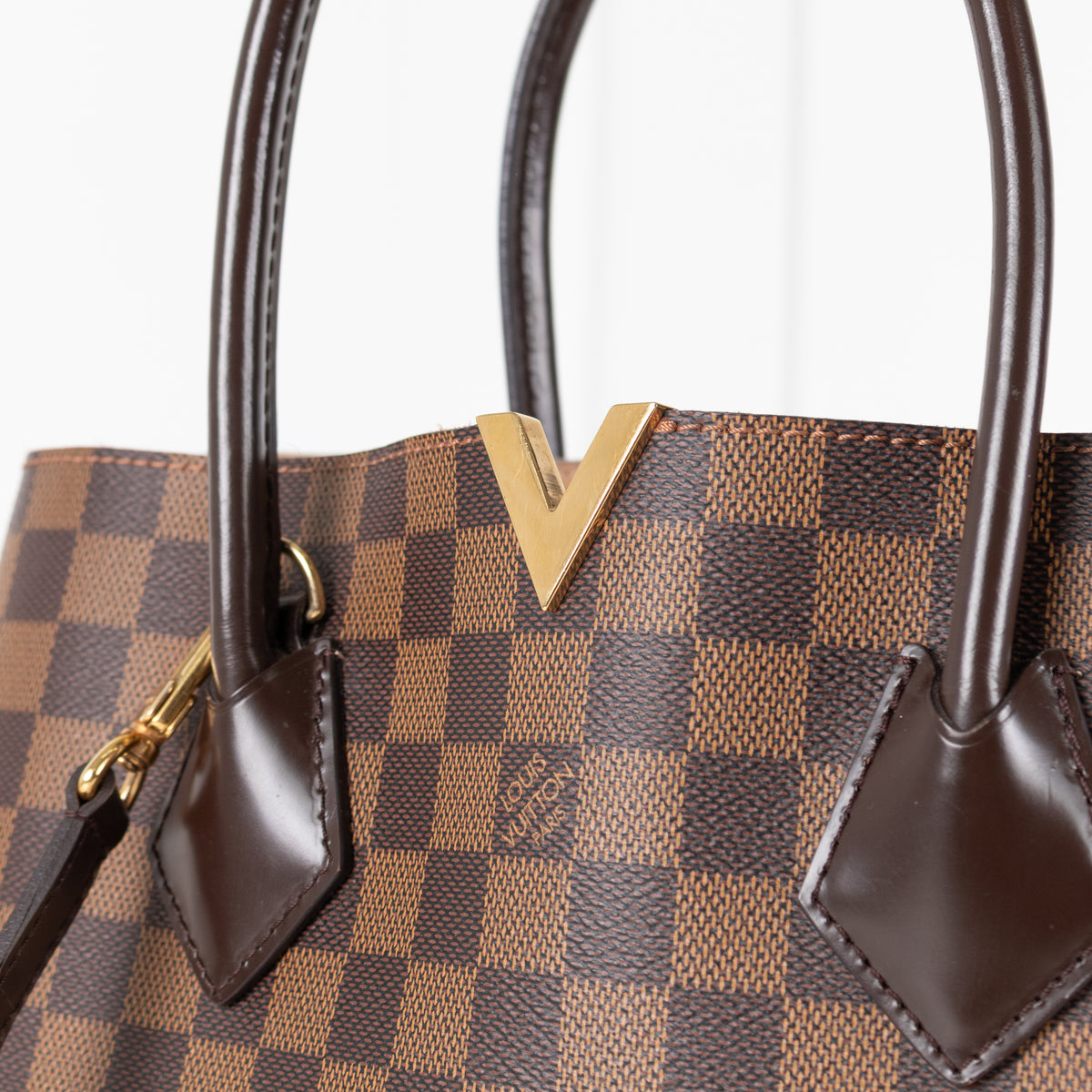 Close of brown leather straps Louis Vuitton Damier Kensington Tote bag. 