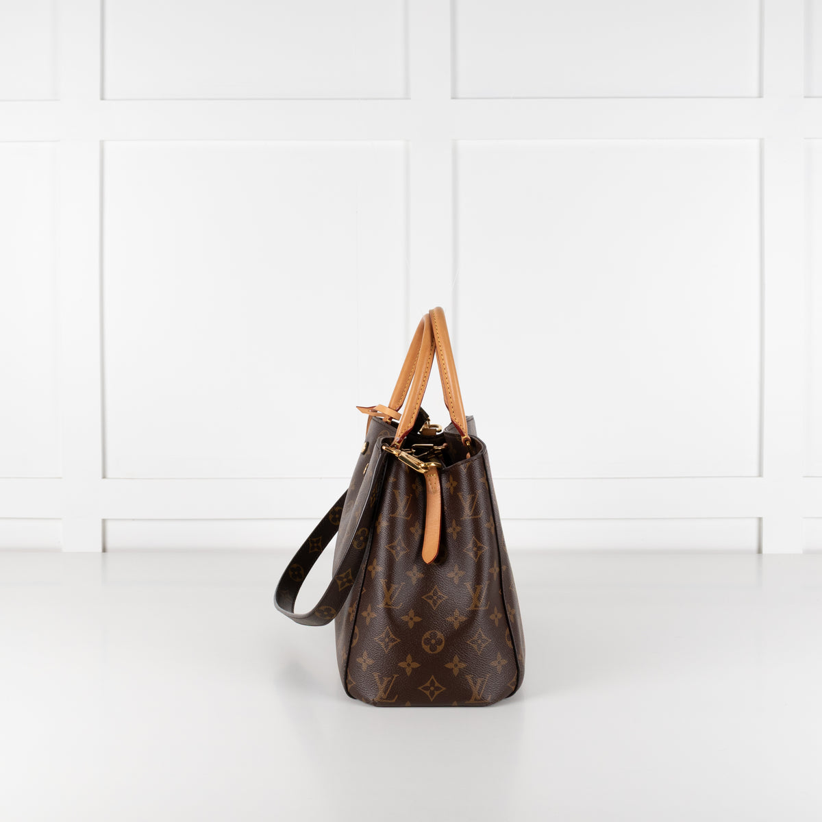 Side profile of Louis Vuitton Monogram Canvas Montaigne MM bag on white background.
