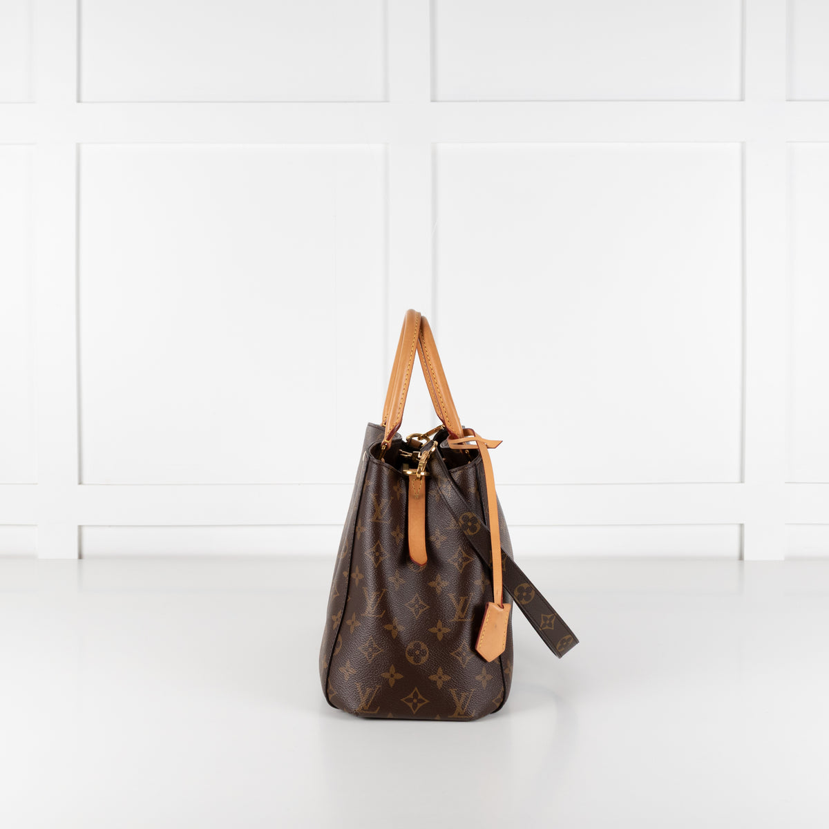 Side profile of Louis Vuitton Monogram Canvas Montaigne MM bag on white background.