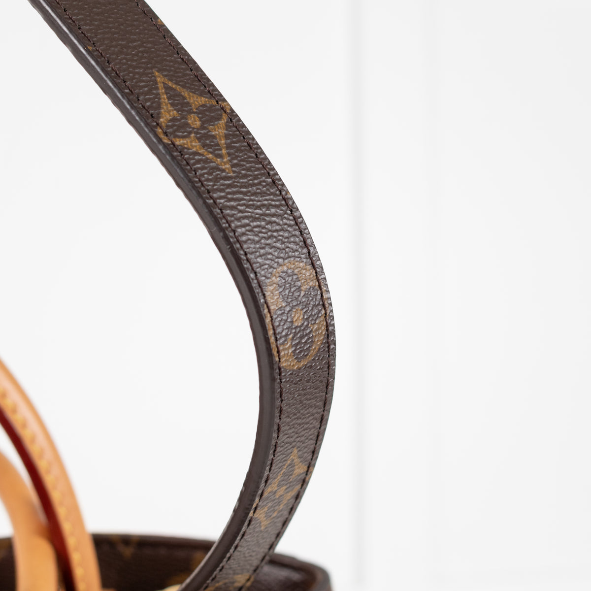 Close up of leather strap Louis Vuitton Monogram Canvas Montaigne MM bag.