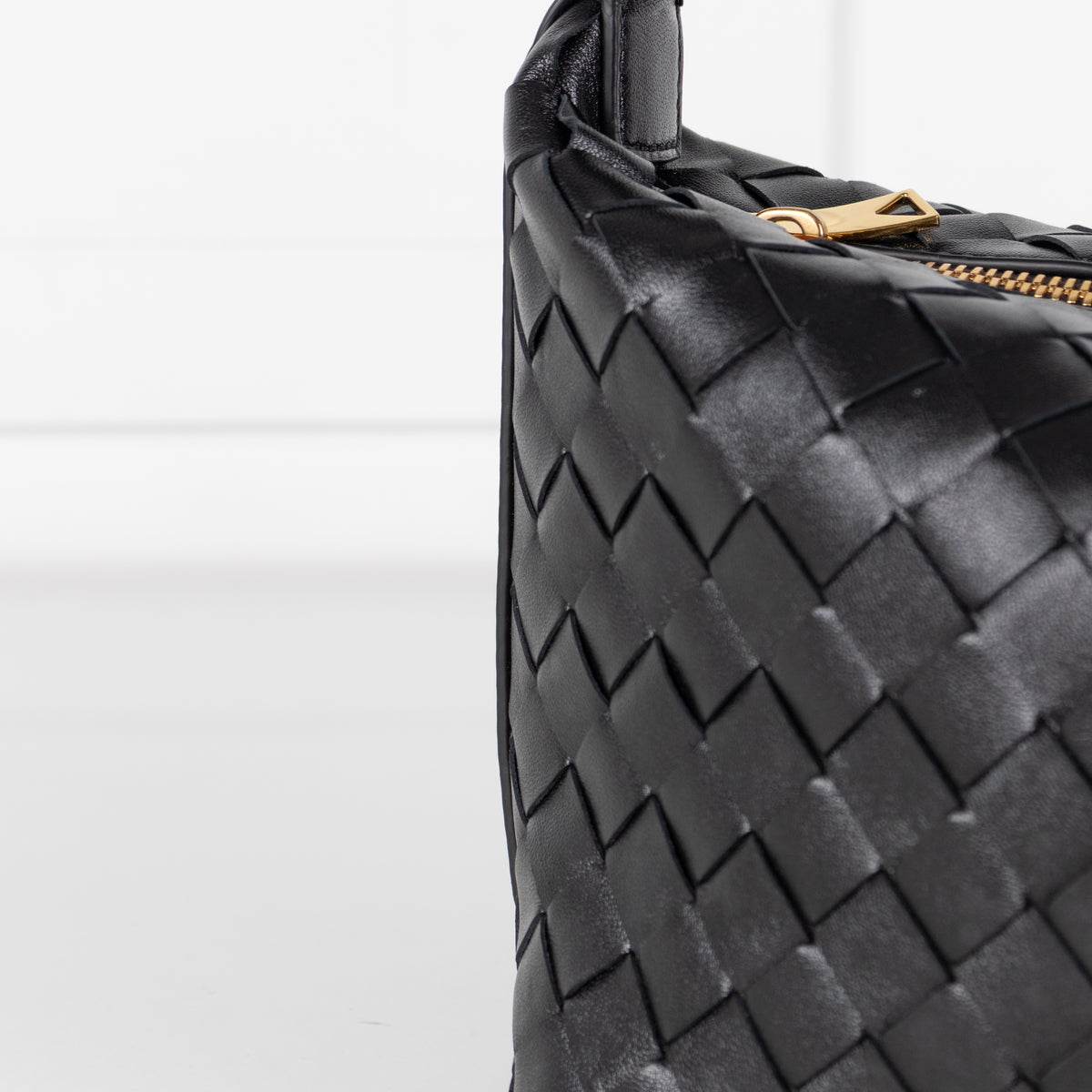 Close up of woven leather pre loved Black Bottega Veneta mini Wallace bag in intrecciato leather on white background in phoenix style store.
