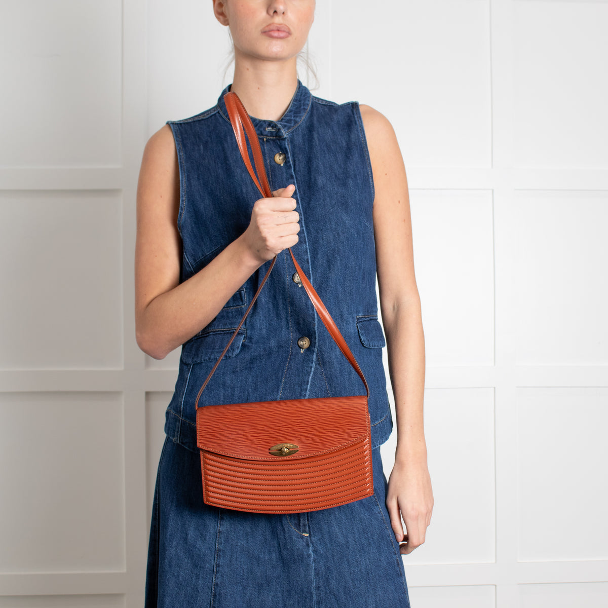 Woman holding Louis Vuitton pre loved handbag. 