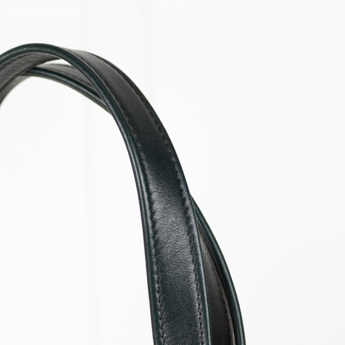 Close-up of a black leather strap on a white background
