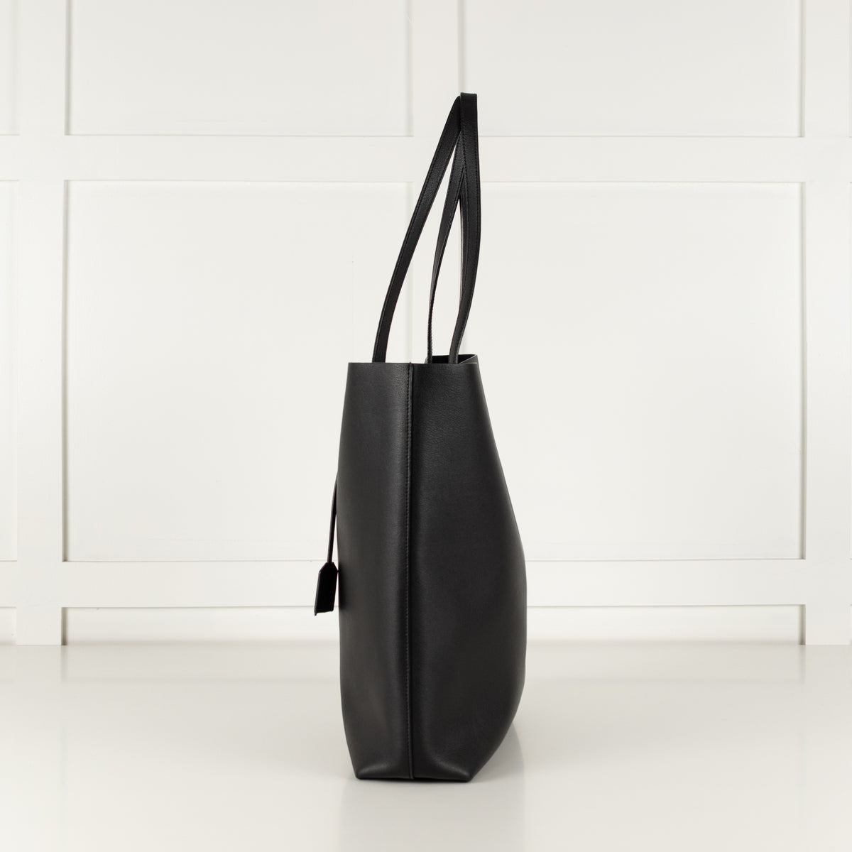 Side profile of a black Saint Laurent tote handbag.