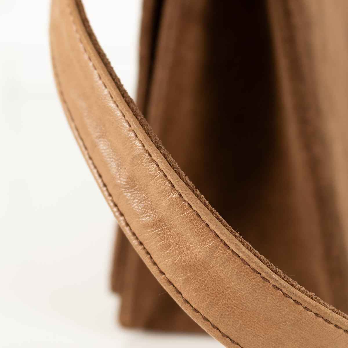 Close-up of a brown leather Chanel flap handbag product on a white background
