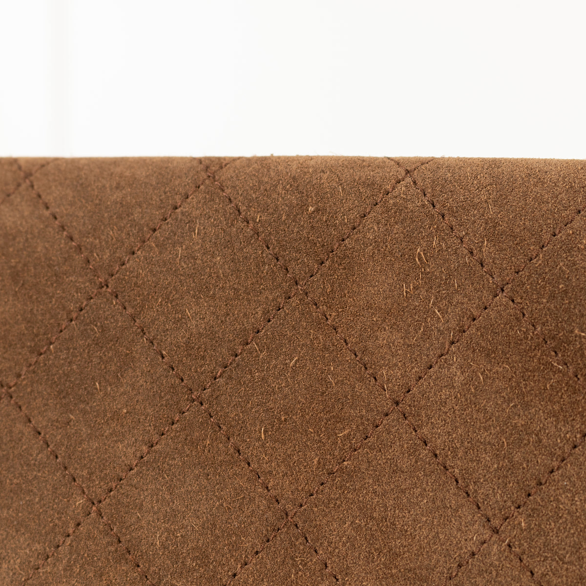 Close up of a Chanel Brown Suede Quilted Flap Bag.