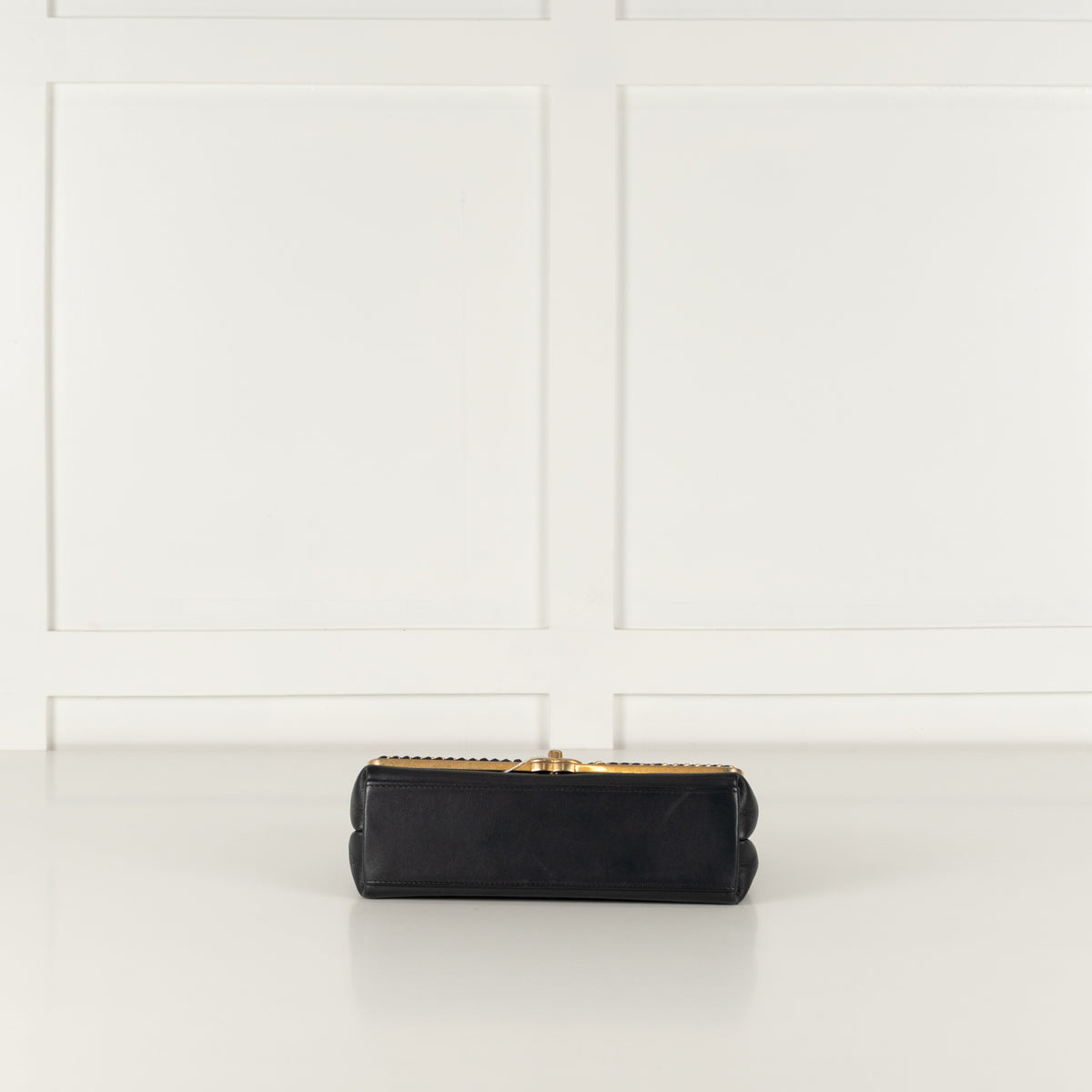 Underneath of Navy Preloved Chanel Handbag on white background.