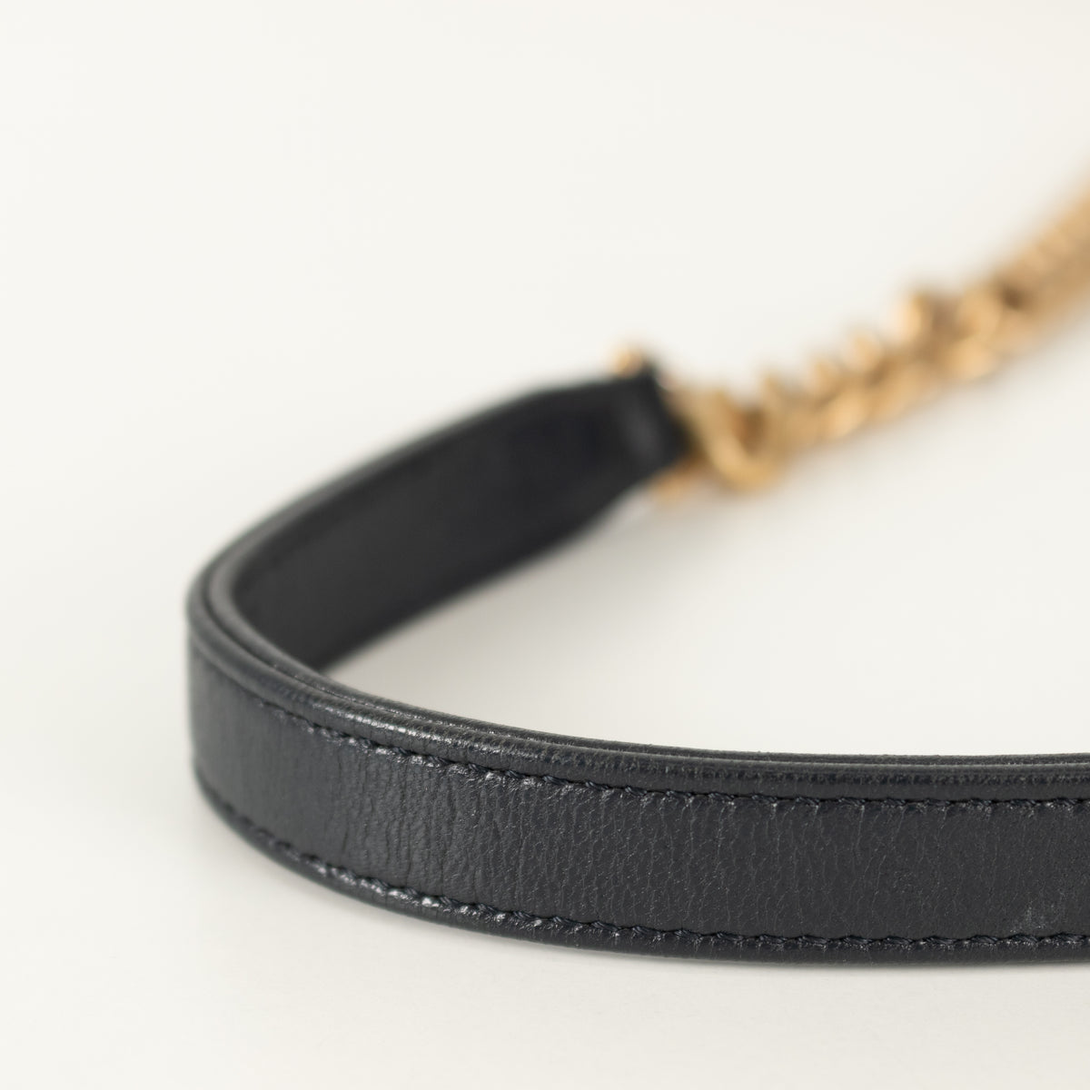 Close up of Navy Chanel leather handle with white background. 