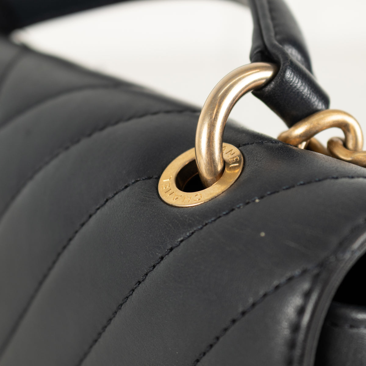 Close-up of a Navy Chanel quilted handbag with gold hardware on a blurred background