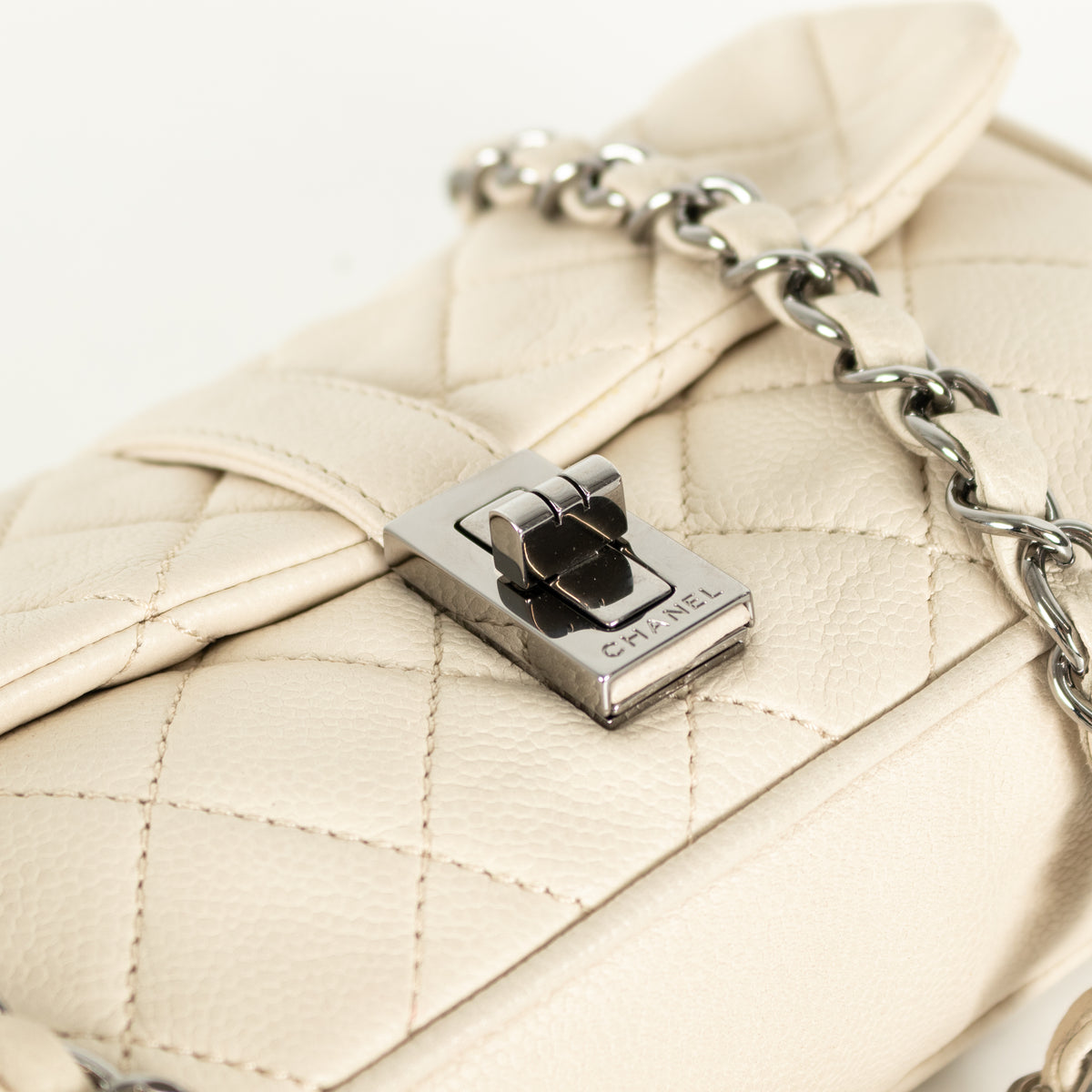 Close up of silver hardware of Preloved Chanel vintage Mademoiselle flap handbag with white background in phoenix style shop.