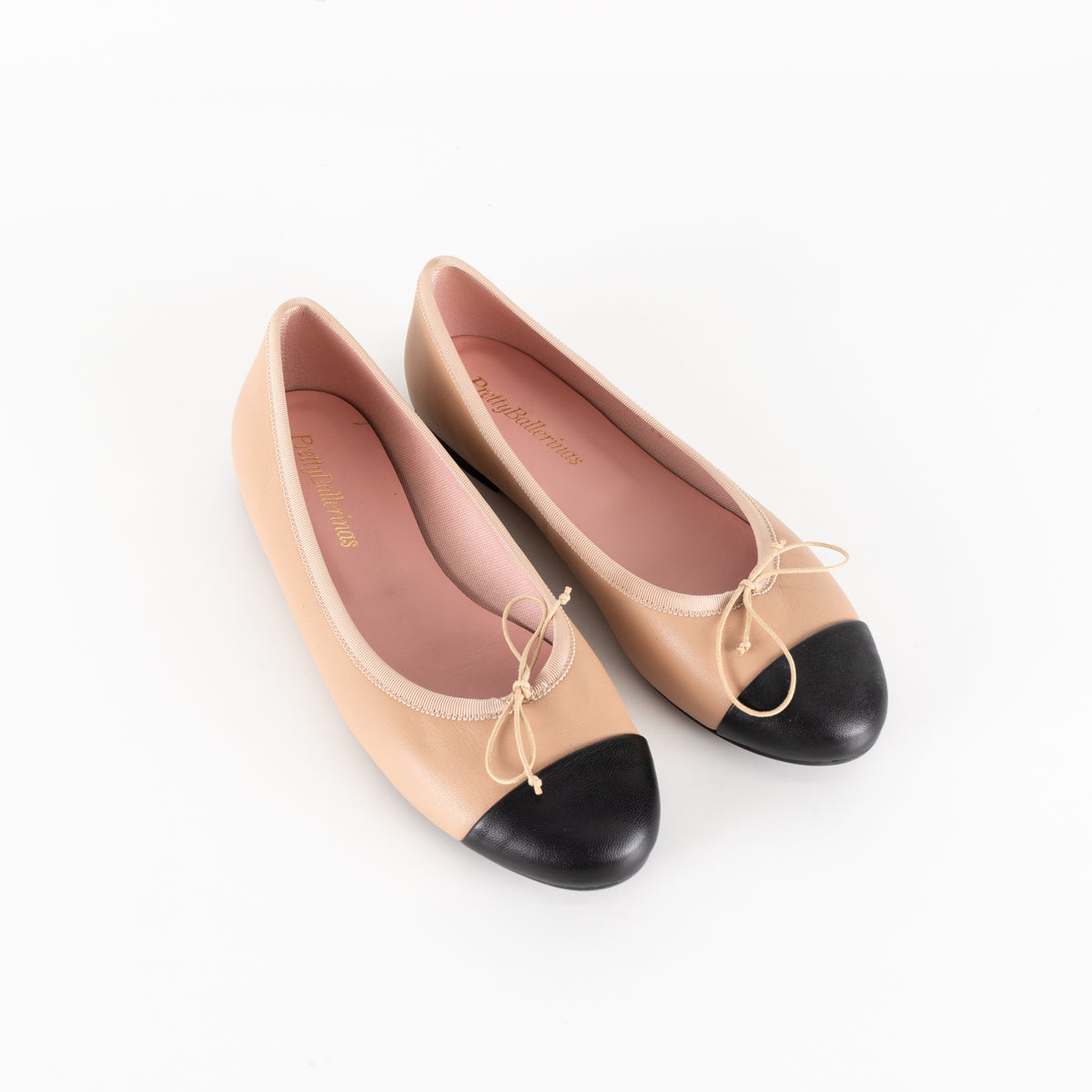 Pretty Ballerinas Nude Ballet Flats With Black Cap-Toe And Bow Detail