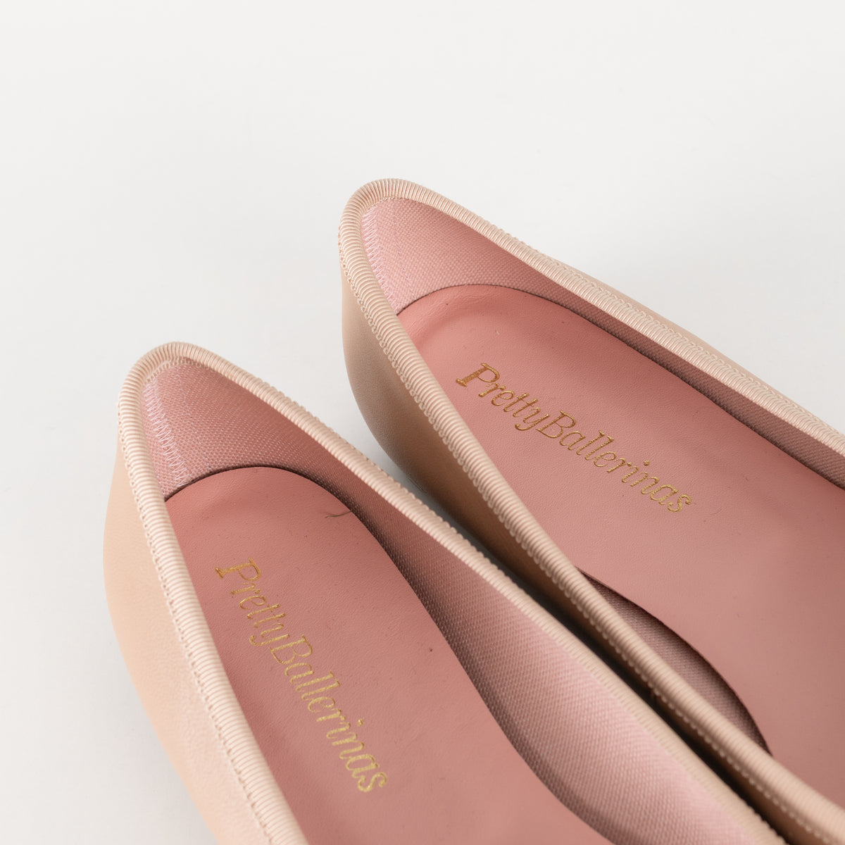 Pretty Ballerinas Nude Ballet Flats With Black Cap-Toe And Bow Detail