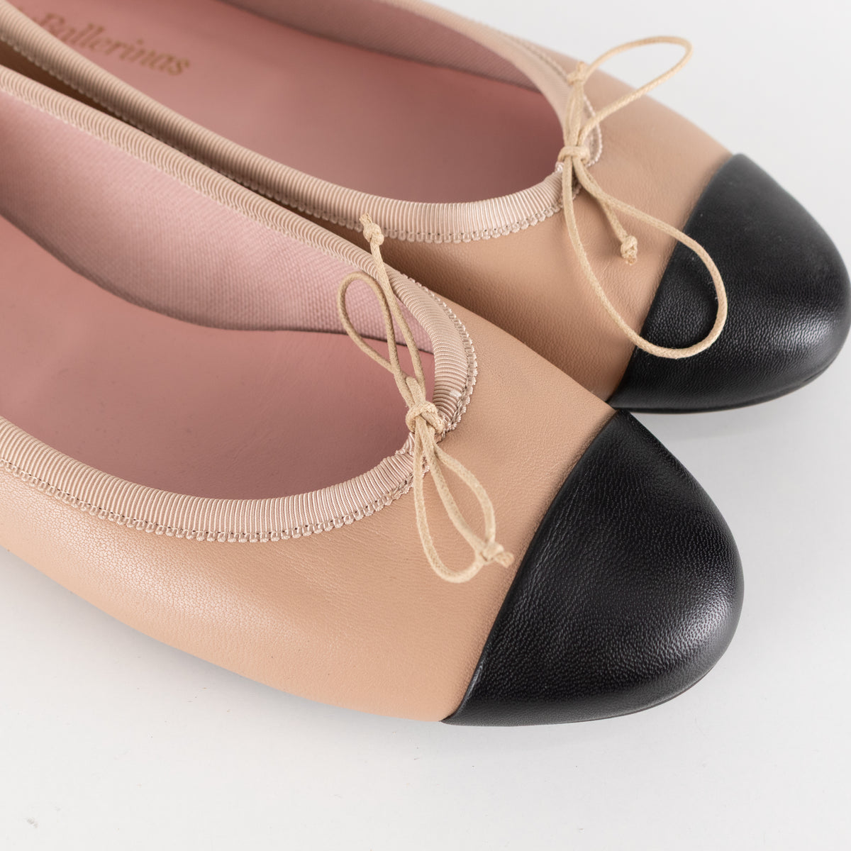 Pretty Ballerinas Nude Ballet Flats With Black Cap-Toe And Bow Detail