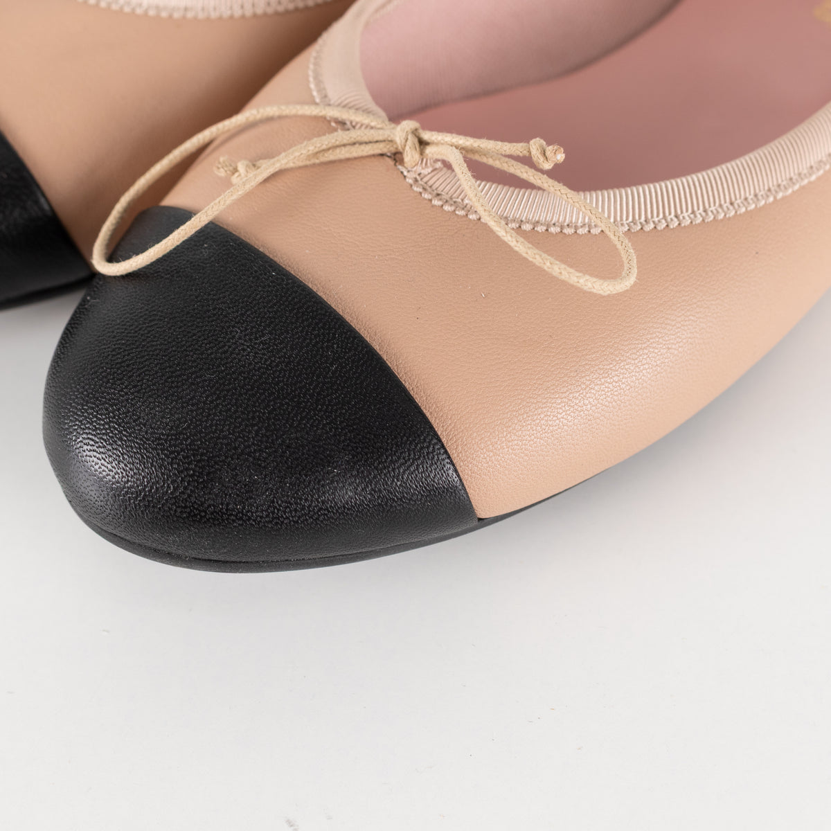 Pretty Ballerinas Nude Ballet Flats With Black Cap-Toe And Bow Detail