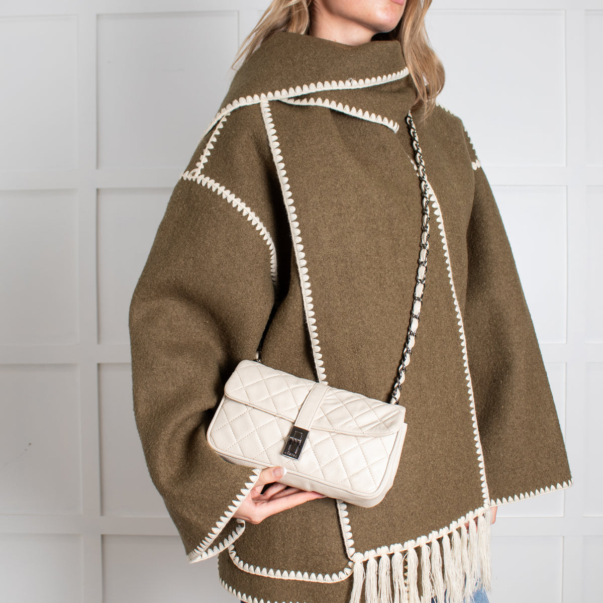 Model holding Chanel cream flap bag 