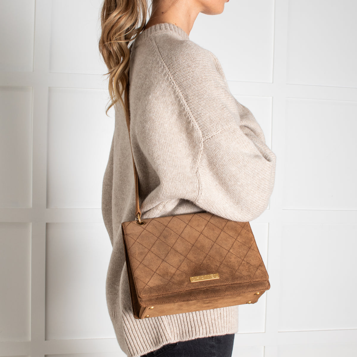 Model wearing Chanel Brown Suede Quilted Flap Bag on a white background in Phoenix Style.
