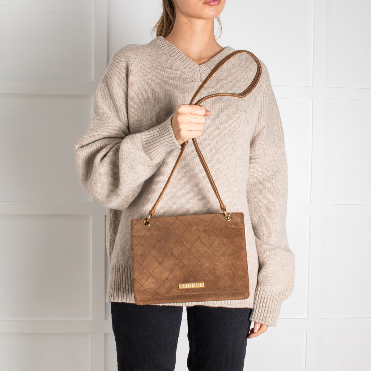 Model holding a Preloved Chanel Brown Suede Quilted Flap handbag in Phoenix Style shop.