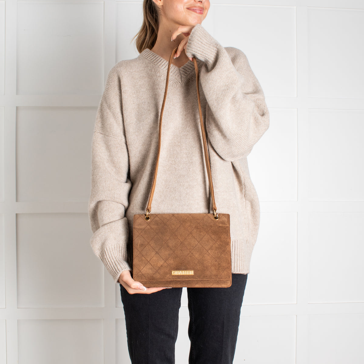 Model holding pre-loved Chanel Brown Suede Quilted Flap Bag