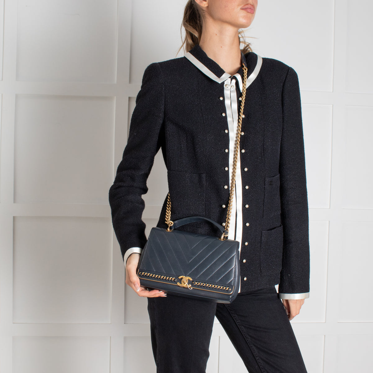 Navy Preloved Chanel Handbag on white background worn by a model.