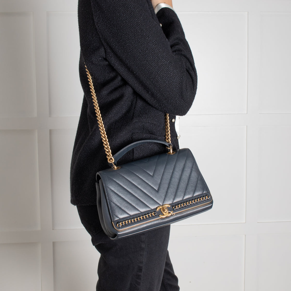 Person wearing crossbody Navy Preloved Chanel Handbag on white background.